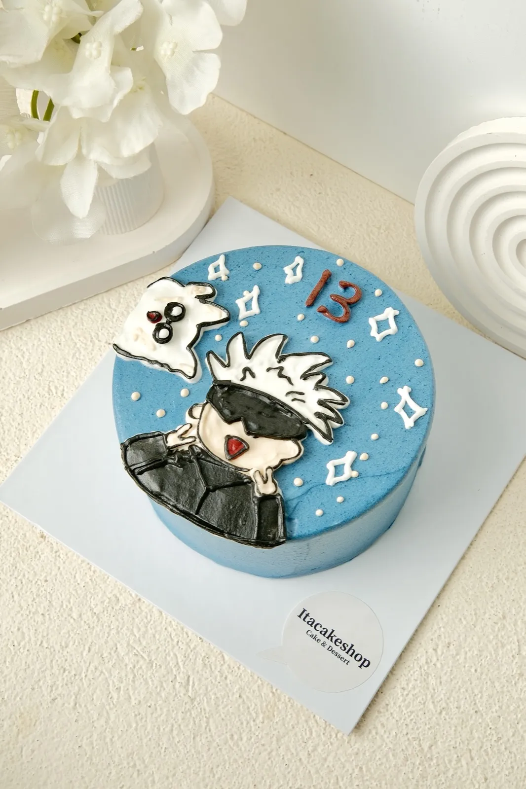 Cake custom krim biru dengan hiasan karakter anime dan angka 13
